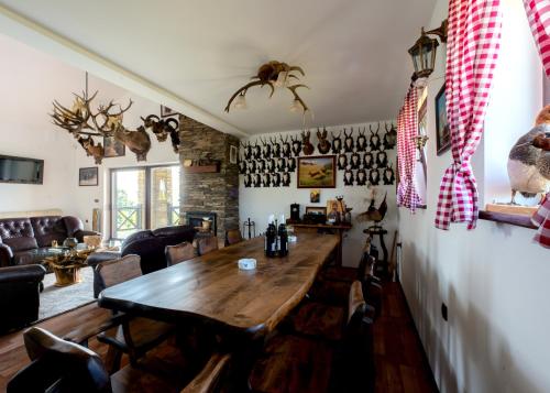 a dining room with a wooden table and chairs at Vila Pellegrini in Arandjelovac