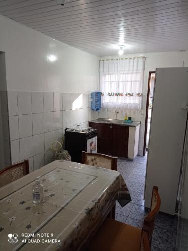a room with a table and a kitchen with a counter at Casa Recanto 2 in Campos do Jordão