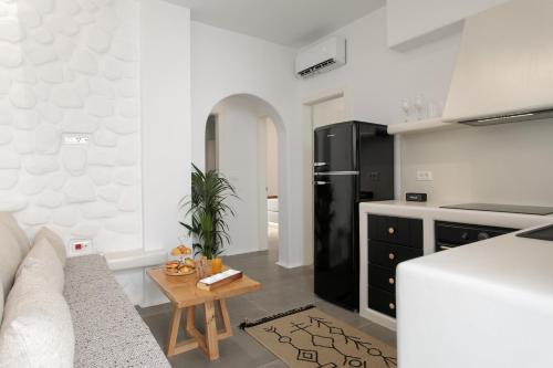 a kitchen with a couch and a table in a room at Kamvas Deluxe Apartments in Naxos Chora