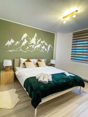 a bedroom with a bed with mountains painted on the wall at Tudor's Mountain Retreat in Câmpina