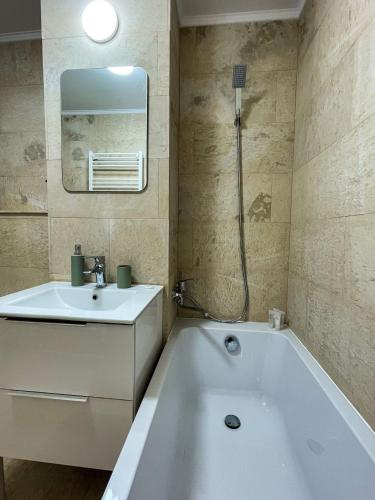 a bathroom with a white tub and a sink at Tudor's Mountain Retreat in Câmpina