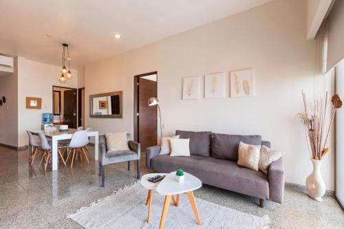a living room with a couch and a table at Infinito Condos in Playa del Carmen