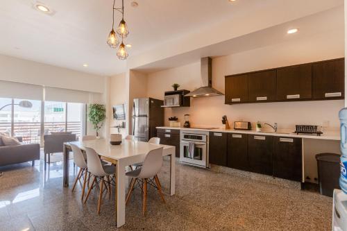a kitchen and living room with a table and chairs at Infinito Condos in Playa del Carmen