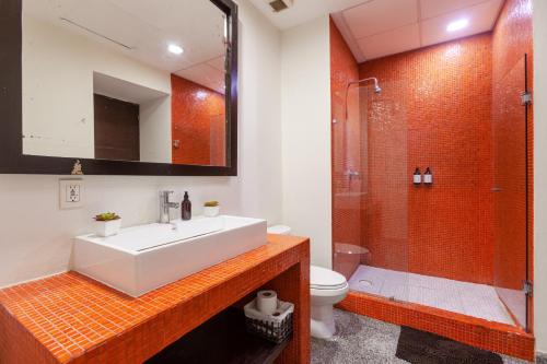 a bathroom with a white sink and a shower at Infinito Condos in Playa del Carmen