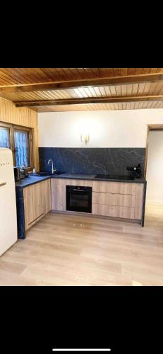 une grande cuisine avec un comptoir noir dans l'établissement Nouveau - plein centre Valberg - App 6 couchages, à Péone