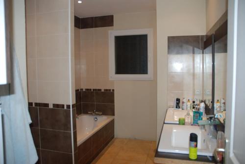 a bathroom with a bath tub and a sink at Villa la magnifique : piscine , spa , 140m2 in Vailhauquès