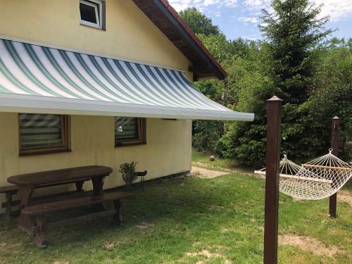 a patio with a hammock and a house at Słonik in Stegers