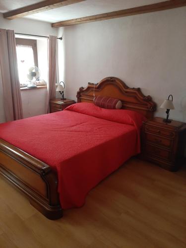 Casa Elena في نوس: غرفة نوم بسرير احمر مع لحاف احمر