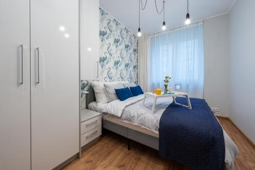 a bedroom with a bed with blue and white walls at Apartment BlueBird Katowice near Spodek MCK & City Center in Katowice