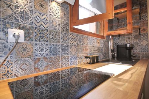 a kitchen with blue and white tiles on the wall at Dafnes in Skopelos Town
