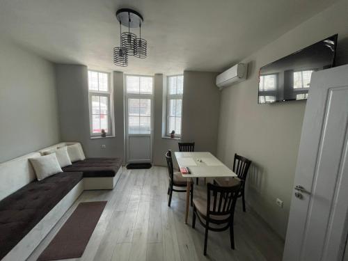 een woonkamer met een bed en een tafel en stoelen bij Dream in Varna