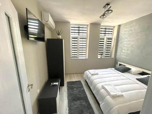 a bedroom with a large white bed and windows at Dream in Varna City