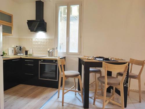 une cuisine avec une table et des chaises dans une cuisine dans l'établissement le jardin botanique, à Perpignan