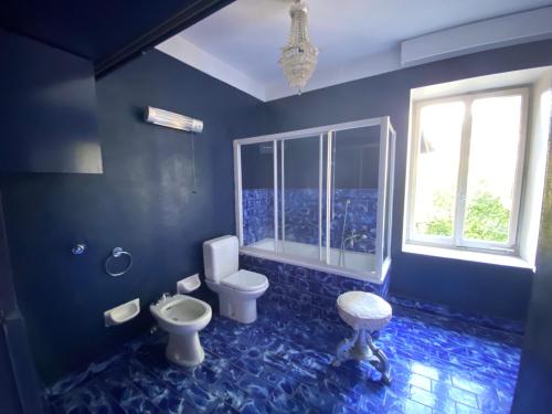 bagno blu con servizi igienici e lavandino di Castello mit Park a Ponte Tresa