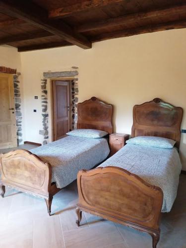 two beds in a room with two bedsitures at BeB LORTALLINO in Ameno