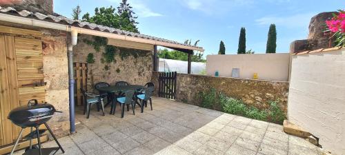 um pátio com uma mesa, cadeiras e uma cerca em Gîte la Libellule 4 couchages 15 min du Puy du Fou em Saint-Amand-sur-Sèvre