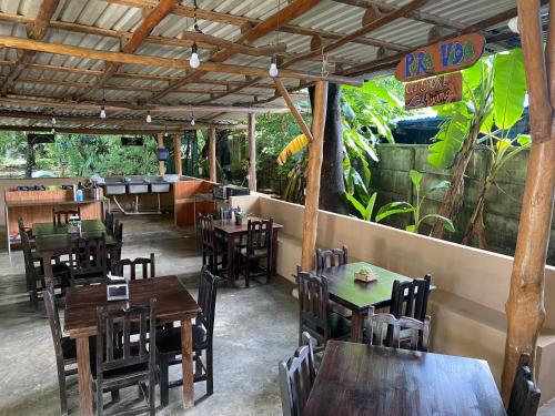 a restaurant with wooden tables and chairs and a patio at Casa del Sol in Santa Teresa Beach