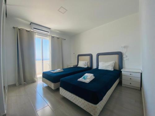 een slaapkamer met 2 bedden en een raam met uitzicht op de oceaan bij Borda d`Água, Praia da Oura in Albufeira