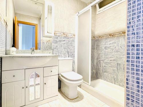 Un baño con inodoro, lavabo y ducha. en Sea View Escape in La Garrofa, en La Garrofa