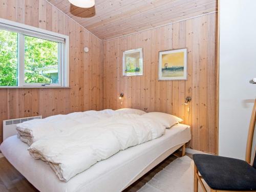 a bed in a room with wood paneling at Three-Bedroom Holiday home in Tarm 5 in Hemmet