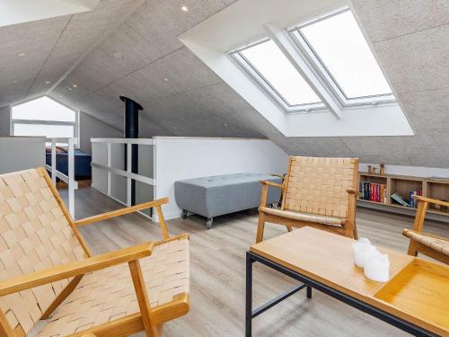 een woonkamer met 2 stoelen en een bed bij Three-Bedroom Holiday home in Løkken 32 in Løkken