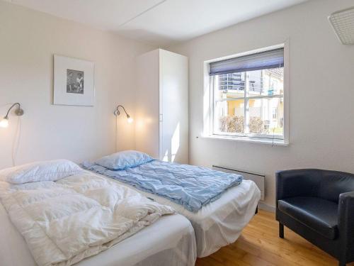 een slaapkamer met een bed, een stoel en een raam bij Apartment Hals IV in Hals