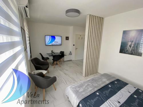 sypialnia z łóżkiem, stołem i krzesłami w obiekcie VeLa Apartments w mieście Ičići