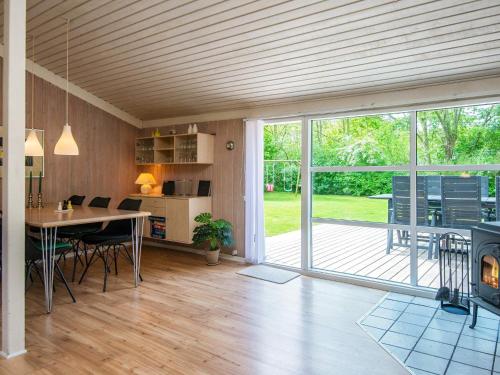 a living room with a dining table and a large sliding glass door at 6 person holiday home in Hemmet in Hemmet