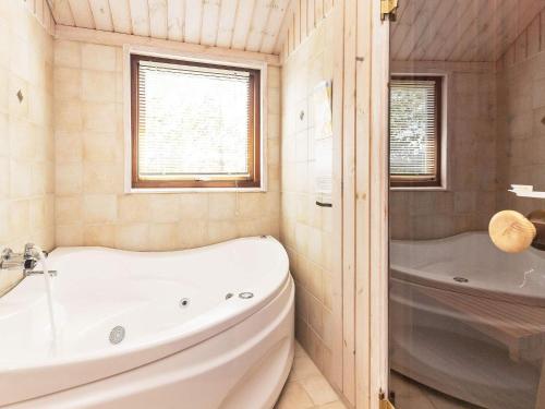 ein Badezimmer mit einer Badewanne und einer weißen Badewanne in der Unterkunft 8 person holiday home in Fjerritslev in Torup Strand