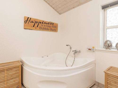 a bathroom with a toilet and a sign that reads happiness is a true half buffalo at 8 person holiday home in Hirtshals in Hirtshals