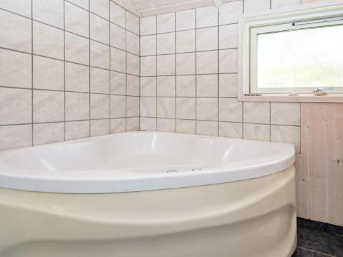 eine weiße Badewanne im Bad mit Fenster in der Unterkunft 8 person holiday home in Hemmet in Hemmet