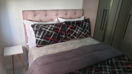 - un lit avec une tête de lit et 2 oreillers dans l'établissement Apartamento Aconchegante Esteio - Coração da Grande Porto Alegre, à Esteio