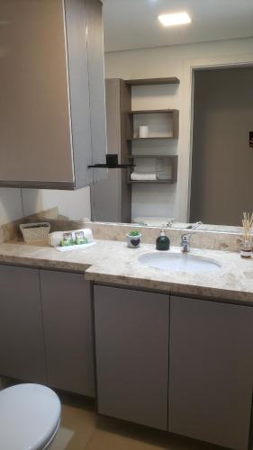 une salle de bain avec un lavabo et des toilettes dans l'établissement Apartamento Aconchegante Esteio - Coração da Grande Porto Alegre, à Esteio