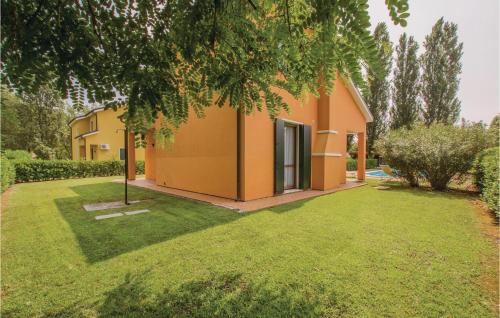 a house with orange walls and a yard at 3 Bedroom Cozy Home In Albarella Ro in Isola Albarella