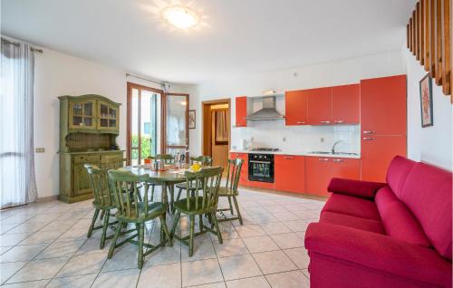 a kitchen and dining room with a table and a couch at 3 Bedroom Cozy Home In Albarella Ro in Isola Albarella