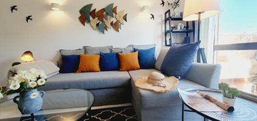 een woonkamer met een blauwe bank en een glazen tafel bij Villa charmosa V2 junto à praia e à Marina de Vilamoura in Quarteira