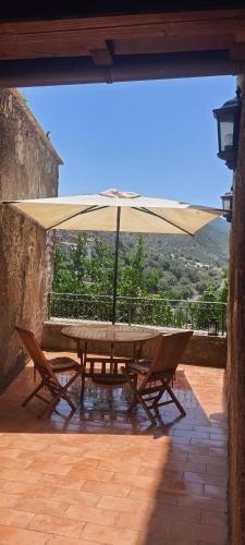 un tavolo e sedie con ombrellone su un patio di casa vacanze belvedere a Sermoneta