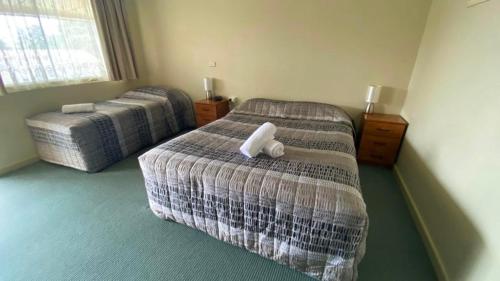 a hotel room with two beds and a window at Bucketts Way Motel Gloucester in Gloucester