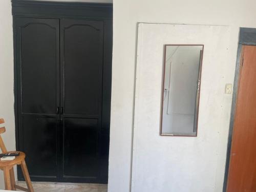 um espelho numa parede ao lado de uma porta preta em Sophia House em Cartagena das Índias