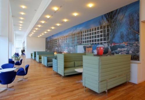 a waiting room with desks and chairs and a painting on the wall at Hotel Hiberus in Zaragoza