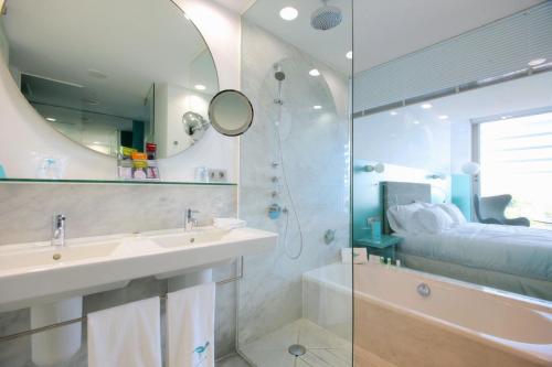 a bathroom with a sink and a tub and a mirror at Hotel Hiberus in Zaragoza