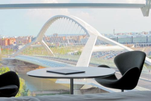 a table and chairs in a room with a bridge at Hotel Hiberus in Zaragoza