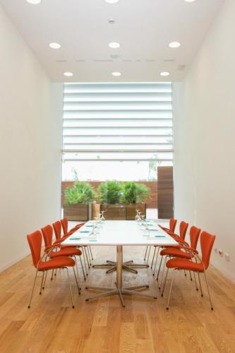 a table and chairs in a room with a large window at Hotel Hiberus in Zaragoza