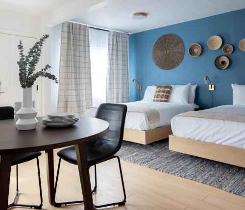 a bedroom with two beds and a table and chairs at Kettle Valley Beach Resort in Penticton