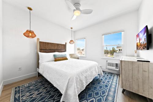 a white bedroom with a bed and a window at The Hideaway Hotel in Long Beach
