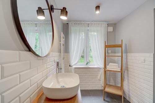 ein Badezimmer mit einer weißen Badewanne und einem Spiegel in der Unterkunft Chata i Mostek in Krynica-Zdrój
