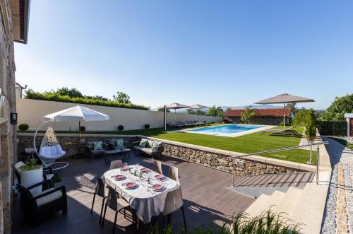 a patio with a table and chairs and a pool at O CERVO CHARM HOUSE in Vila Nova de Cerveira