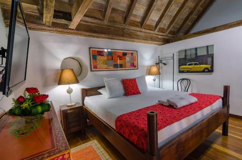 a bedroom with a bed and a table with flowers at Casa Cordoba Román in Cartagena de Indias