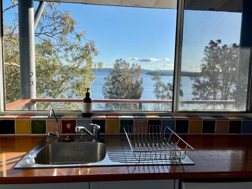 a kitchen sink with a view of a window at Green Point Boat House in Tiona