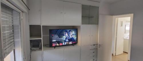 TV en la pared en una habitación con armarios blancos en DEPARTAMENTO CASEROS TRES Dormitorios en Salta